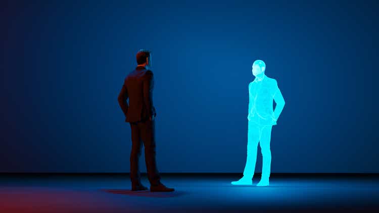 Man looks at a digital avatar of himself made with a hologram