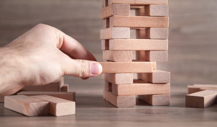 Male hand showing wooden block, Risk. Business