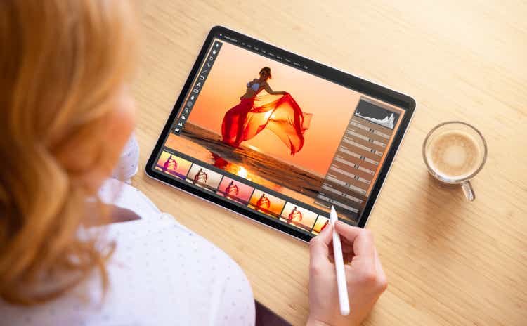 Woman using stylus pen for image editing on tablet computer