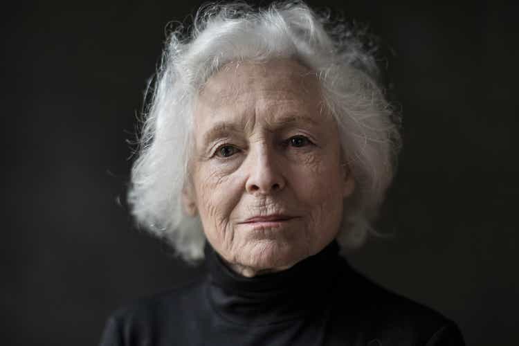 Portrait of serious senior woman against black background