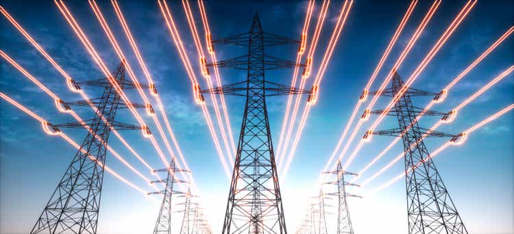 Electricity transmission towers with red glowing wires