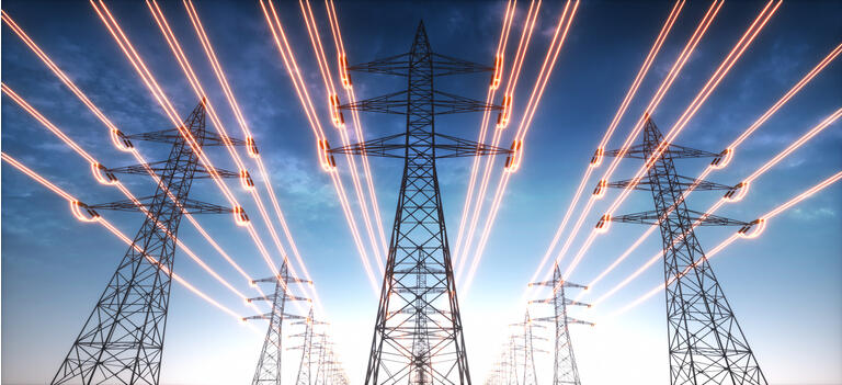 Torres de transmisión de electricidad con cables rojos brillantes