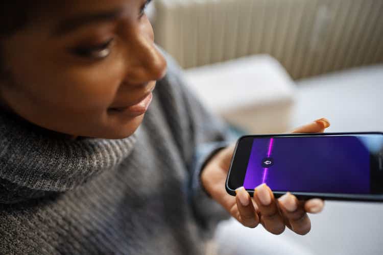 An African woman uses a voice assistant on a smartphone
