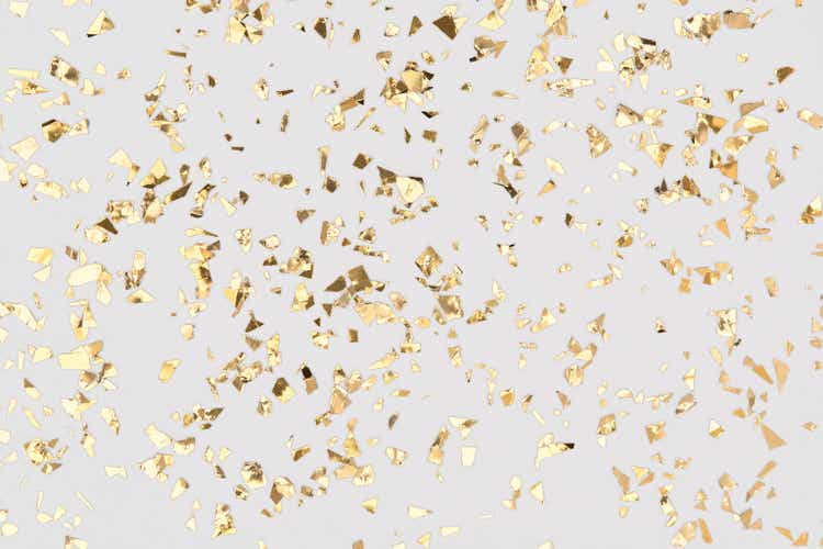 Gold confetti sparkles on white background, golden foil, festive backdrop.