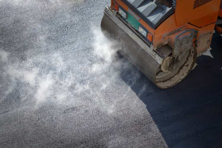 A roller compacting asphalt on a road