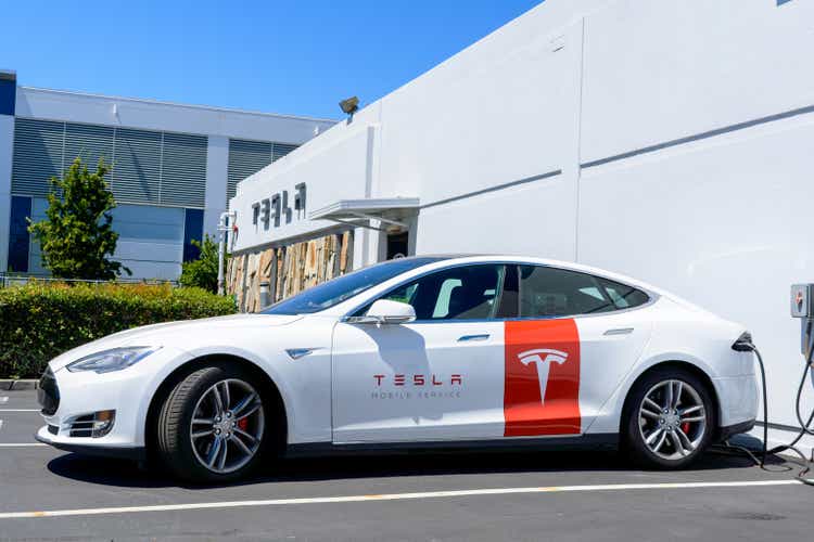 Tesla Mobile Service vehicle is charging outdoor at service center. Side View