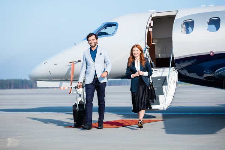 Confident colleagues disembarking private jet