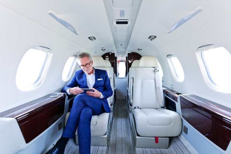 Businessman using tablet PC in private airplane