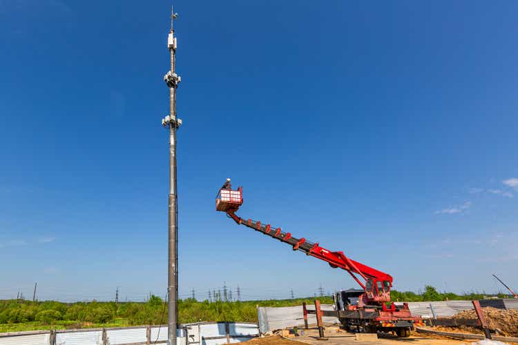 Engineer starts working on the telecommunication tower -cellular phone repeater mast - from An aerial work platform, also known as an aerial device, elevating work platform, cherry picker, bucket truck, mobile elevating work platform.