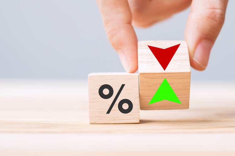 business man Hand change wood cube block with percentage to UP and Down arrow symbol icon. Interest rate, stocks, financial, ranking, mortgage rates and Cut loss concept