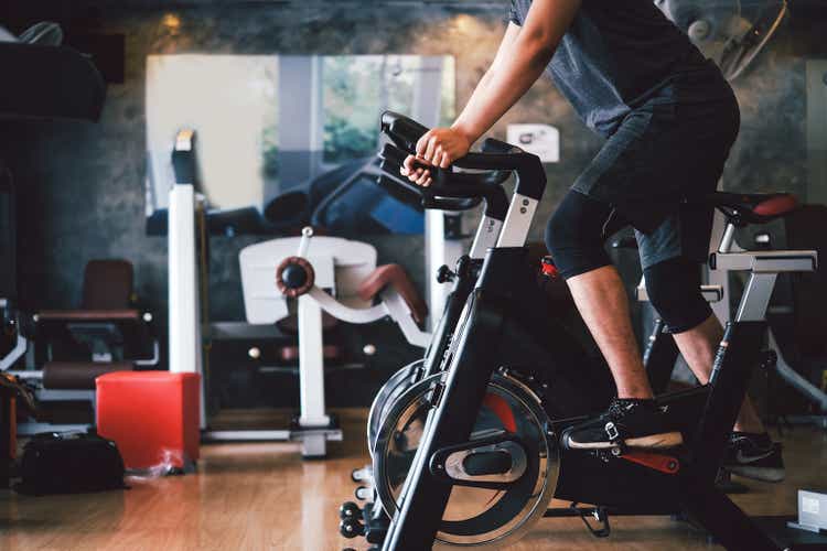 Man exercise by bike at the gym, make their thighs strong and healthy.