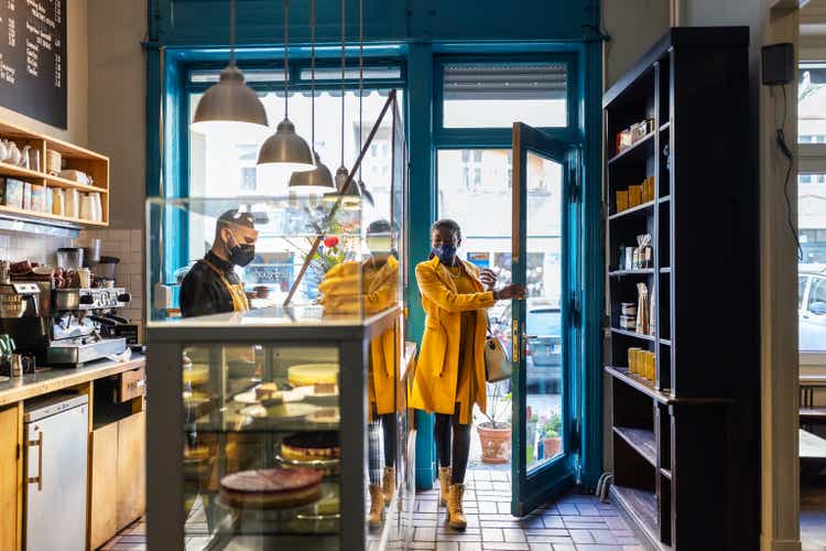 Woman visiting a small coffee shop during pandemic