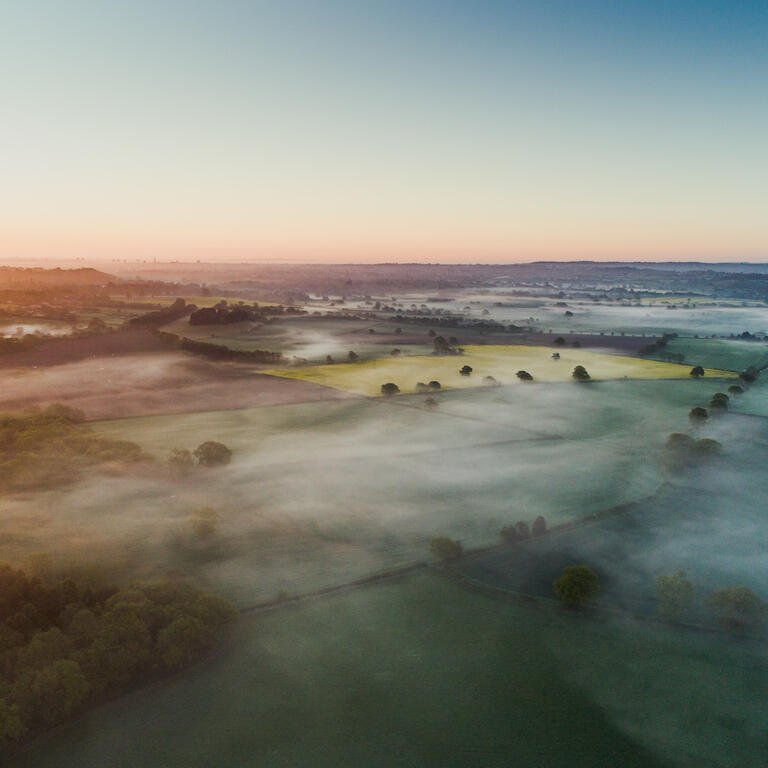 Aerial shot showing a low level mist at sunrise over the English countryside, England, United Kingdom