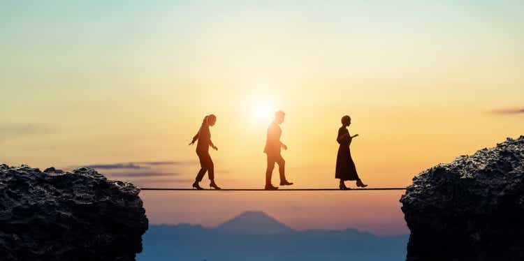 Group of businessperson walking on a tightrope. Risk management.