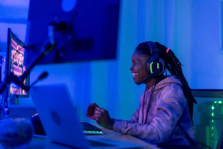 Young black female gamer celebrates at night