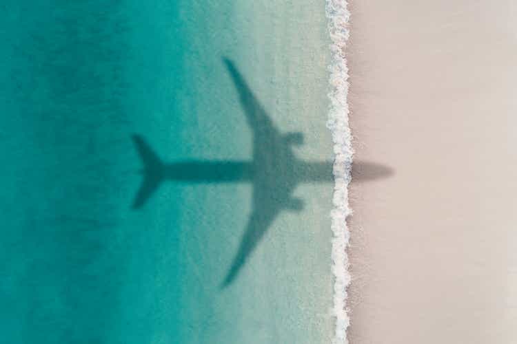 Aerial photograph showing the shadow of an airplane flying over an idyllic beach, Barbados