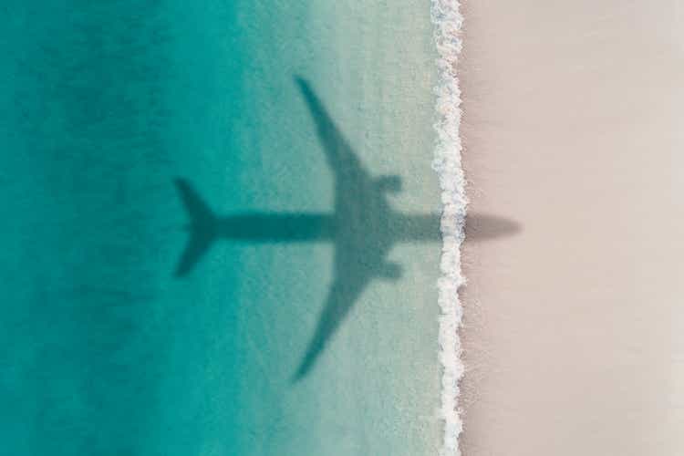 Aerial shot showing an aircraft shadow flying over an idyllic beach scene, Barbados