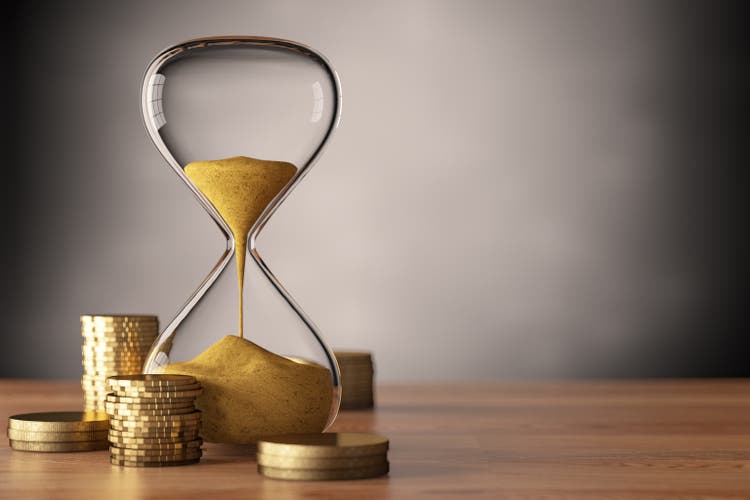Time is Money Concept with Coins and Hourglass
