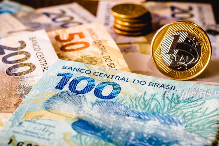 One hundred and two hundred real bills and a highlighted one real coin are shown in this photo illustration. The real is the current money in Brazil