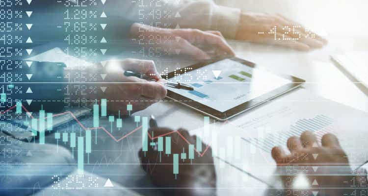 Digitally enhanced shot of a group of unrecognizable businesspeople meeting in the boardroom superimposed over a graph showing the ups and downs of the stock market