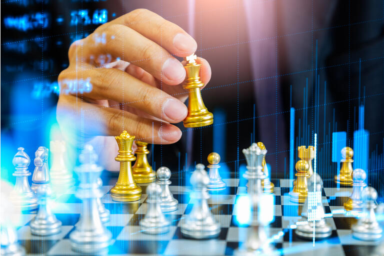 Chess game on chess board behind business man background. Business concept to present financial information and marketing strategy analysis. Investment target in global economy and digital commercial.
