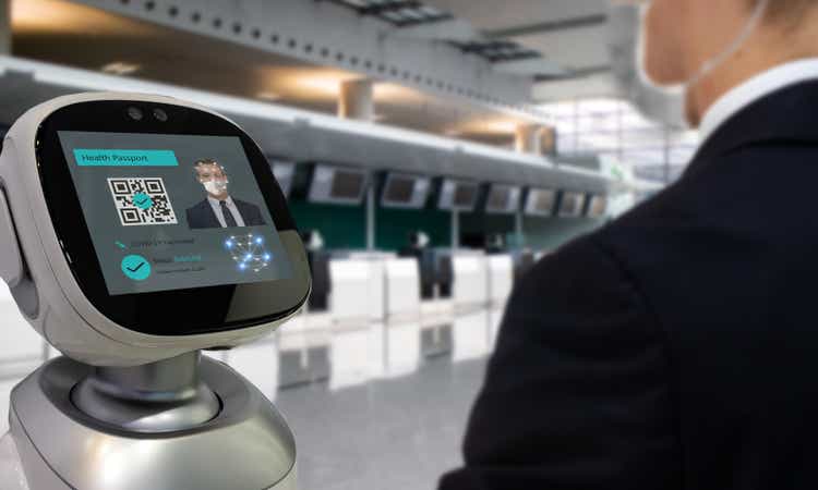 Smart hospitality industry concept, airport or hotel using robot to scan and personal data check with customer who got covid-19 vaccinate by using face recognition detection technology