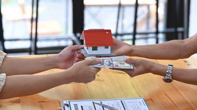 Cropped shot people holding house model .Mortgage loan approval home loan and insurance concept.