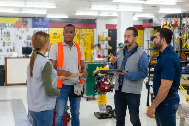 Business owner talking to a group of employees at a hardware store