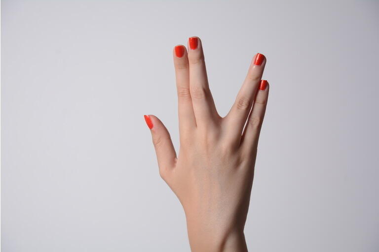 A girl hand doing the Vulcan salute on a white background. Vulcan hand salute against. Spock hand. Alpha.