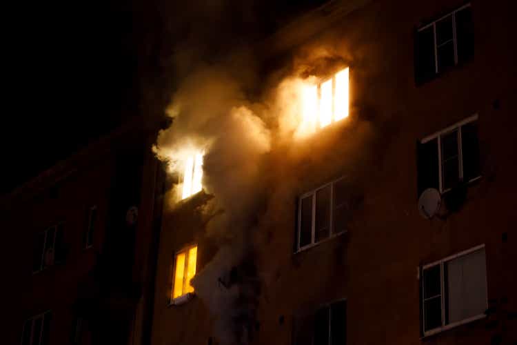 a residential apartment building is on fire at night