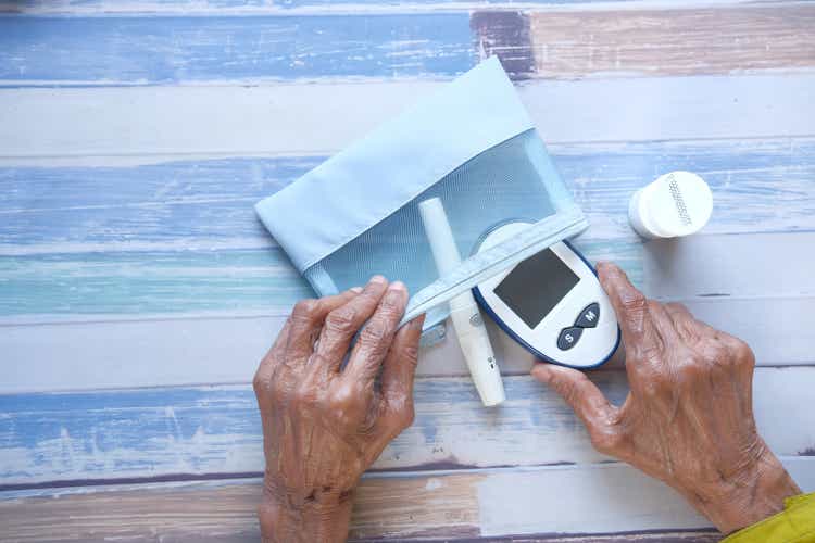 senior women putting diabetic measurement tools on a small bag