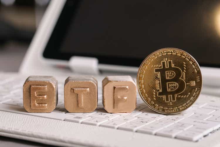 letters Gold ETF and Bitcoin on white keyboard