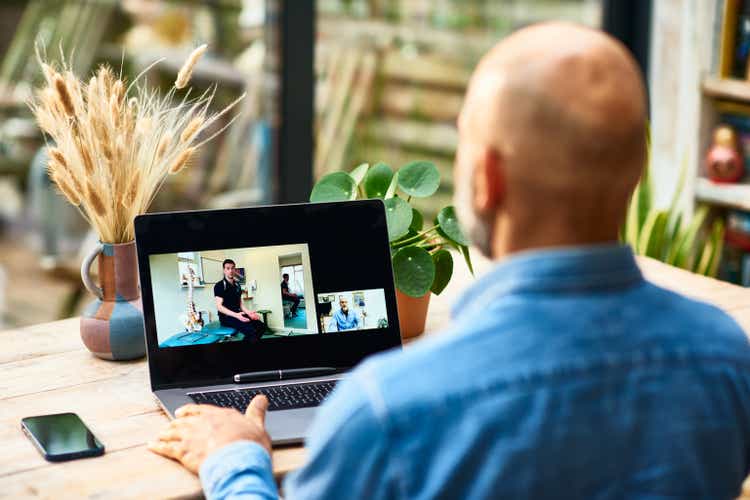 Patient receiving advice on laptop from physical therapist