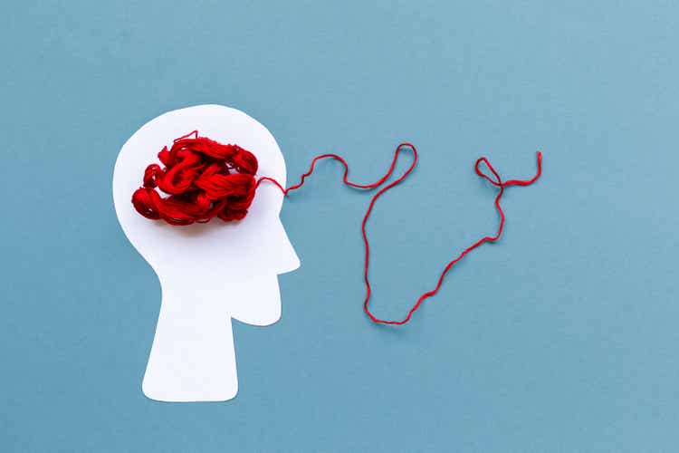 World Alzheimer"s day. Paper silhouette of human head with red tangled threads on blue background. Flat lay. Concept of mental health and dementia