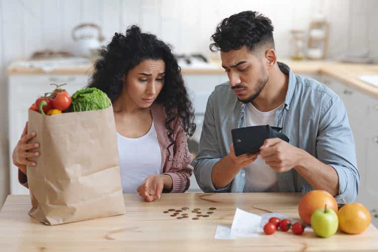 Family Financial Crisis Concept. Upset Arab Spouses Counting Remaining Money After Shopping