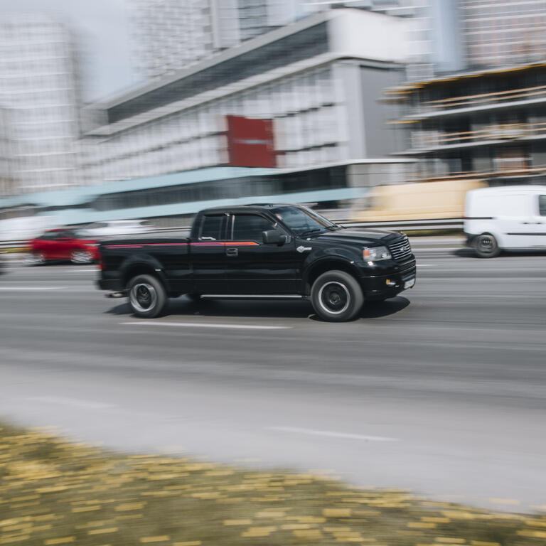 Black Ford F-150 car moving on the street.