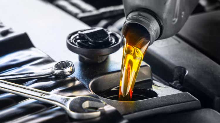 Engine oil for motor vehicles is poured into the engine from a gray bottle