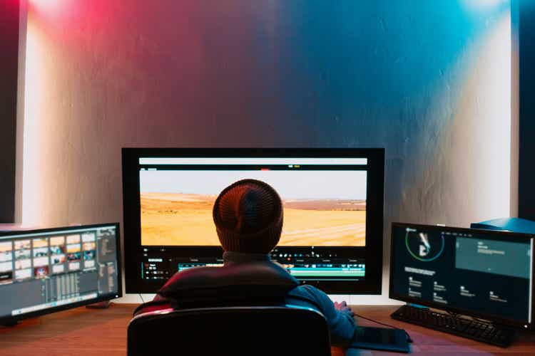 Male Video Editor Working on His Personal Computer with Big Display