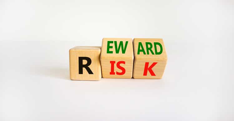 Risk or reward symbol. Turned wooden cubes and changed the word "risk" to "reward". Beautiful white background. Risk or reward and business concept. Copy space.