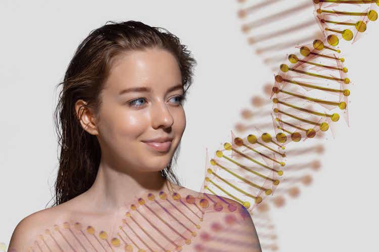 A beautiful woman's face with DNA stems is shown in double exposure on a gray background. science of beauty concept