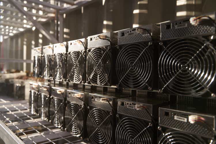 Bitcoin ASIC miners in stock.  ASIC mining equipment on rack for mining cryptocurrency in steel container.  Blockchain technology application-specific integrated circuit devices storage