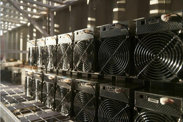 Bitcoin ASIC miners in warehouse. ASIC mining equipment on stand racks for mining cryptocurrency in steel container. Blockchain techology application specific integrated circuit units storage
