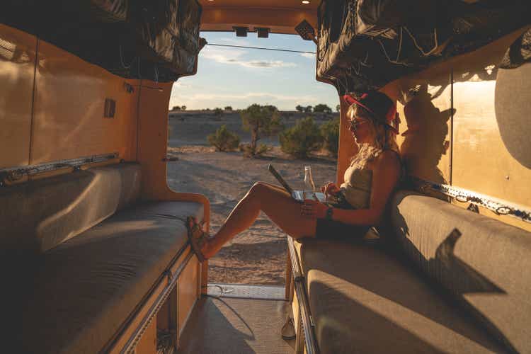 Woman Working On Her Laptop From Her Camper Van, Weekend Getaway, Van Life, Great Outdoors