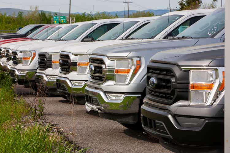 Ford F-150 pickup trucks in dealership parking lot.