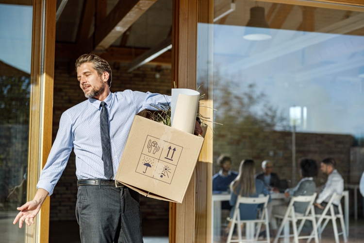 Businessman leaving the office after being fired from his job.