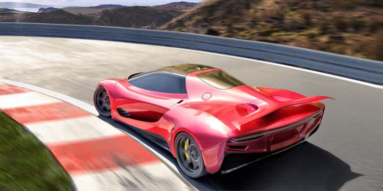 Red Electric Sports Car in Rear View Moving Round Racetrack At High Speed