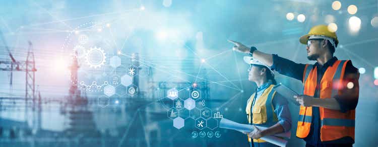 Male and female industrial engineers using tablet computer and blueprints checking and analysis data of power plant station project on network background.