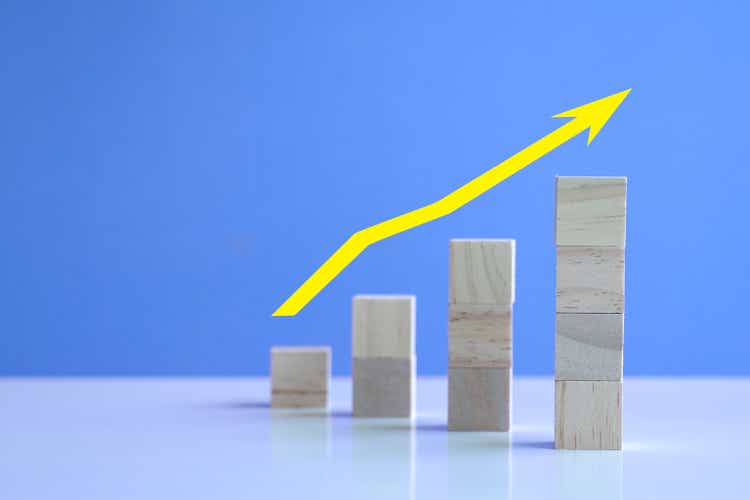 Uptrend with yellow arrow up from stacked wooden cubes.