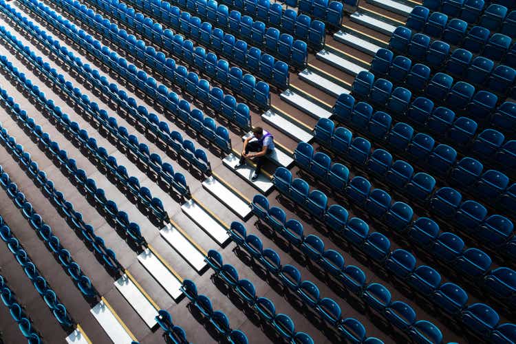 High angle view showing a person sitting amongst empty stadium seating, United Kingdom