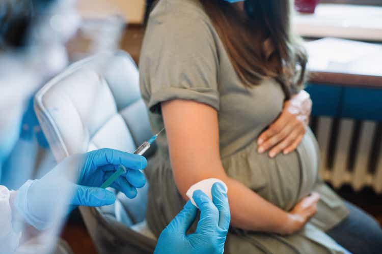 Doctor/nurse giving vaccine injection to pregnant woman